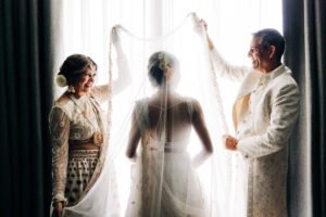 Bride’s parents lifting her veil before the ceremony — a tender pre-wedding moment that reflects the artistry and emotion behind the Average Wedding Photographer Cost in the UK.