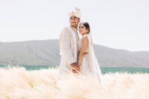 Elegant bride and groom standing in golden fields with scenic views — an example of fine art wedding imagery included in the luxury tier of the Average Wedding Photographer Cost in the UK.