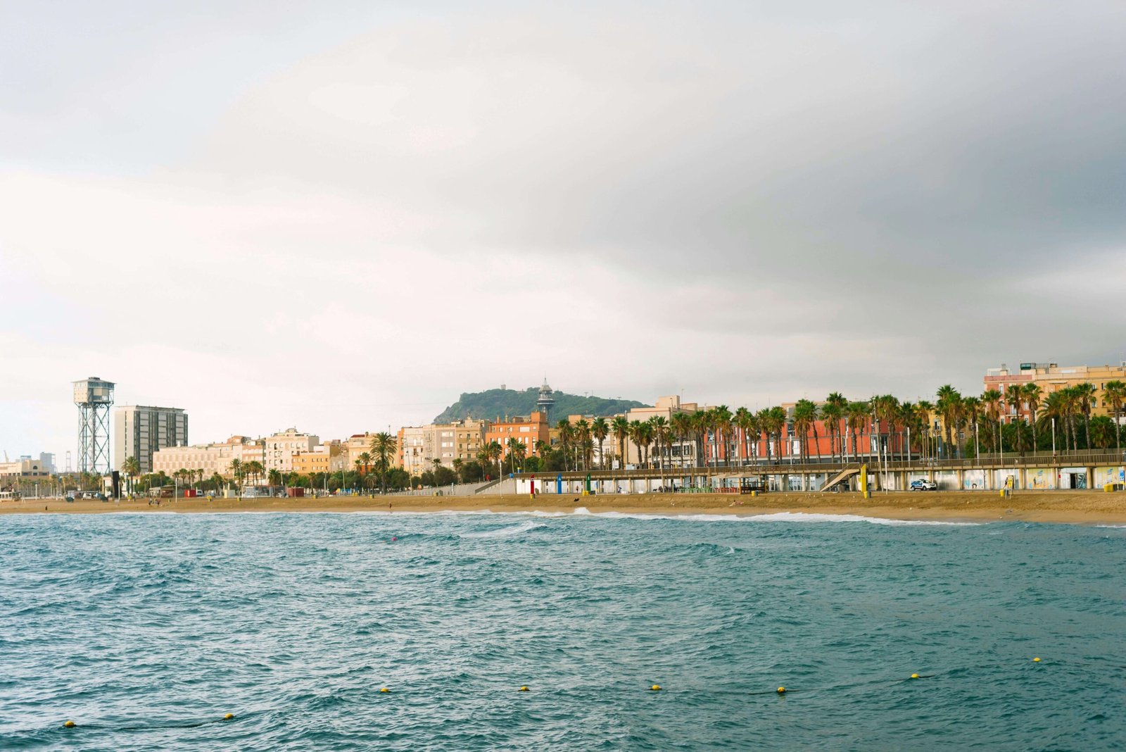 Barceloneta Beach with palm-lined promenade and soft coastal light — a popular location for wedding and engagement photography in Barcelona. Barcelona wedding photographer for destination weddings.
