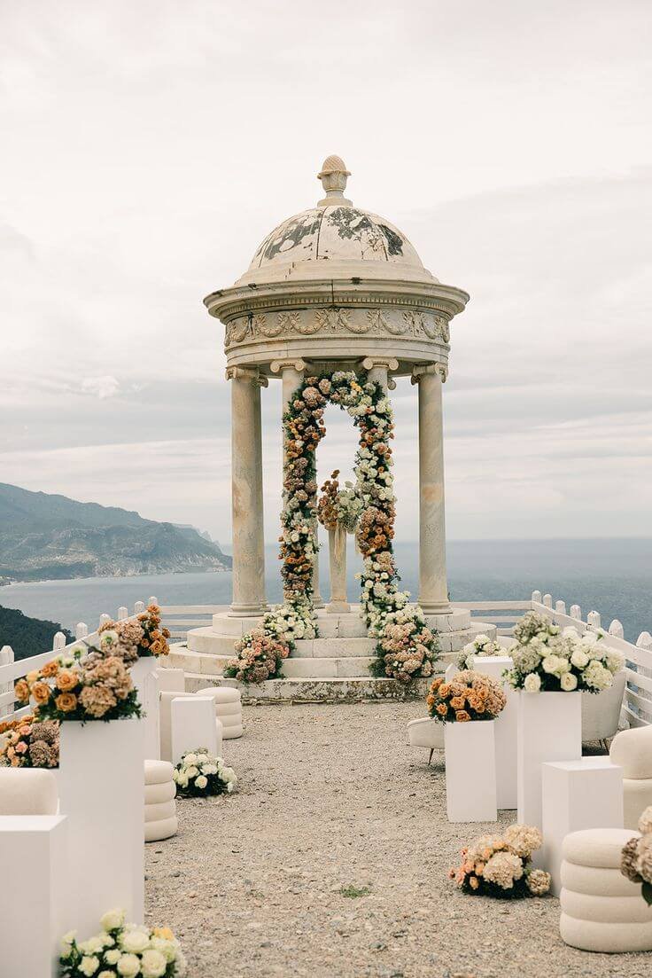 Pinterest / Source: https://www.pinterest.com/pin/388717011603905544/ Floral arch wedding setup at the Son Marroig rotunda overlooking the sea, a stunning highlight in Mallorca Wedding Venues collections