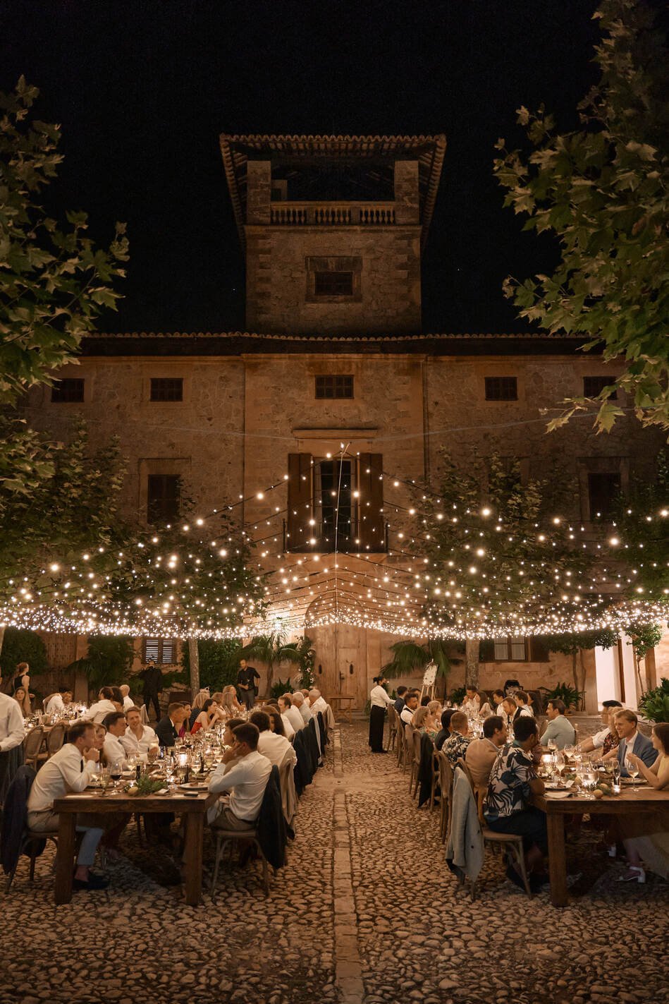 Finca Son Togores / https://www.sontogores.com/en/weddings/ Elegant outdoor wedding dinner under string lights at Finca Son Togores in Mallorca, a romantic celebration often featured in Mallorca Wedding Venues guides.