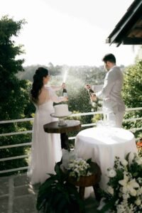 Bali Wedding Photographer for International, Indian and destination weddings: Bride and groom popping champagne as captured by photographer