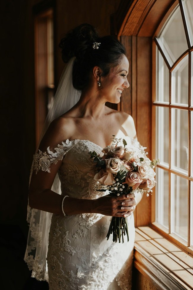 Elegant bride holding bouquet by window light, inspired by best weeding venues in Sorrento, Italy.