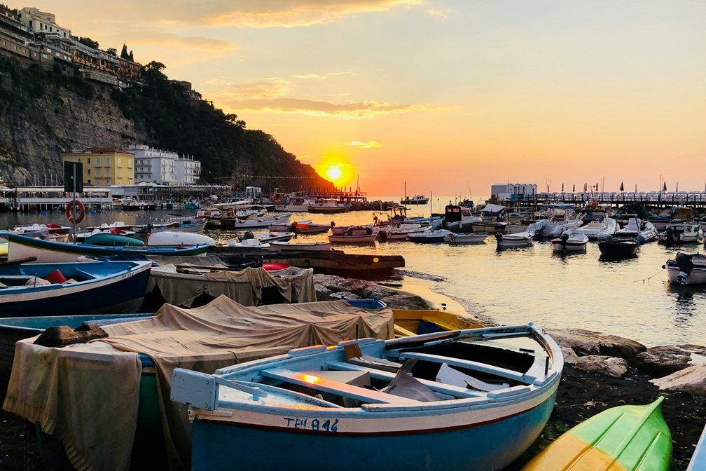 Wedding venues in Sorrento, Italy at sunset with boats in Marina Grande and golden light over the sea