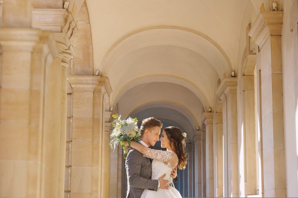 Bride and groom in elegant arcade at wedding venue in Milan, Italy.
